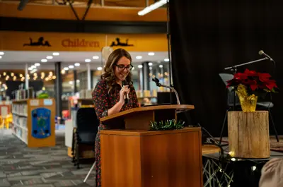 A speaker at the podium introducing an author.