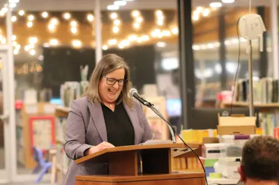 The chair of the library board laughing at the podium.