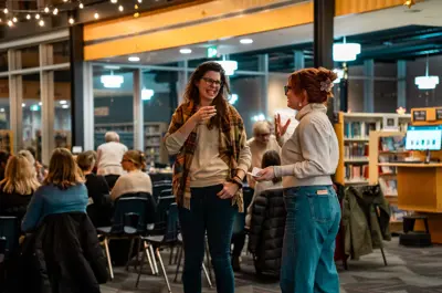 Two guests laughing and sipping wine.